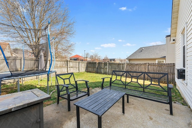 view of patio featuring a trampoline and a fenced backyard