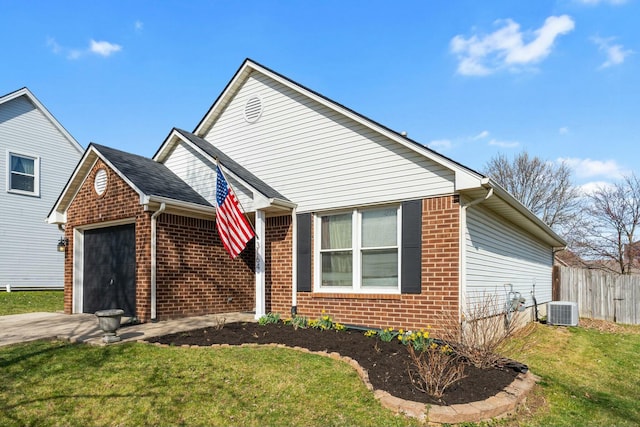 view of front facade with brick siding, fence, a front yard, central AC, and an attached garage