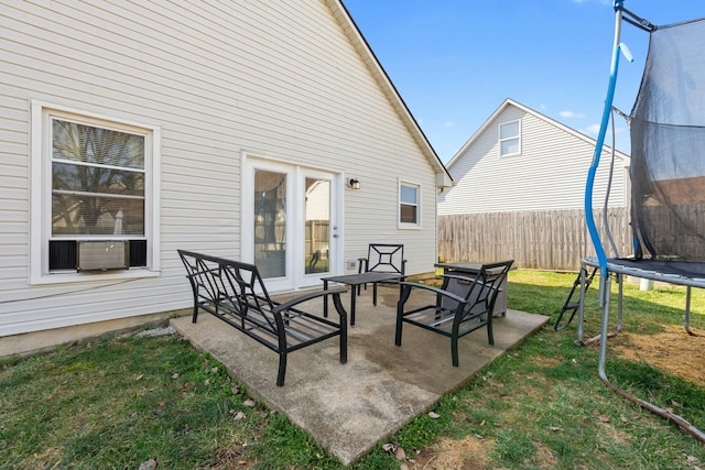 view of patio with a trampoline and fence