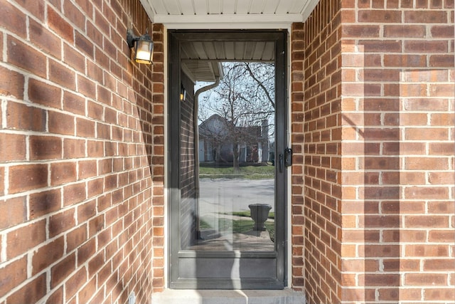 doorway to property with brick siding