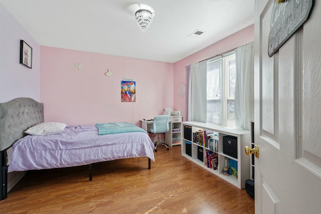 bedroom with visible vents and wood finished floors