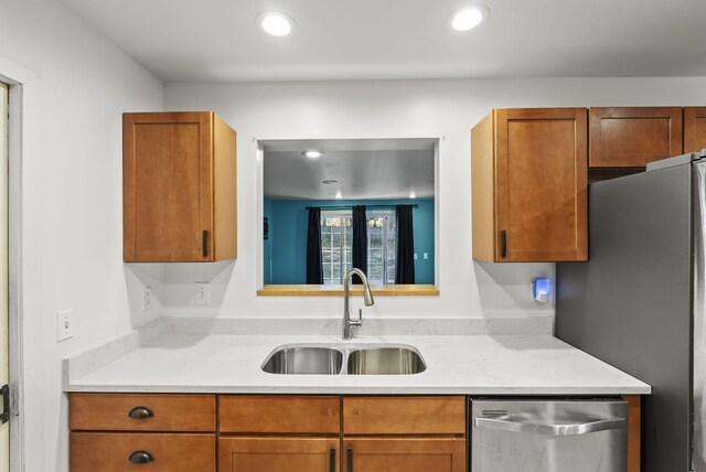 kitchen with a sink, light countertops, brown cabinetry, and stainless steel appliances