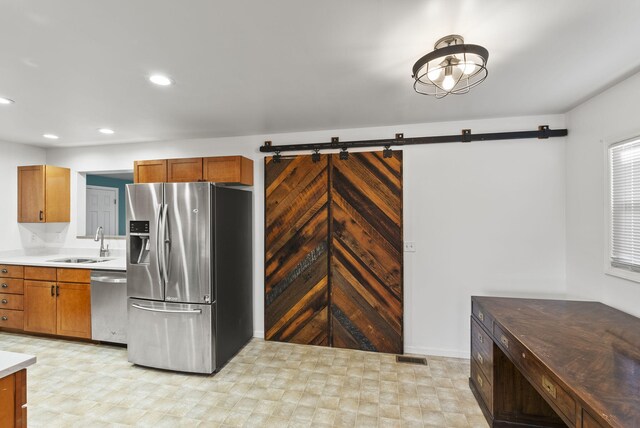 kitchen featuring a sink, stainless steel appliances, recessed lighting, and light countertops