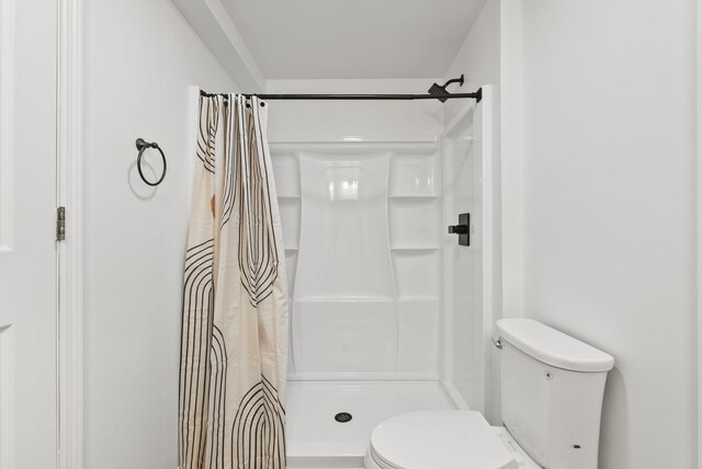 bathroom with toilet and a shower with shower curtain