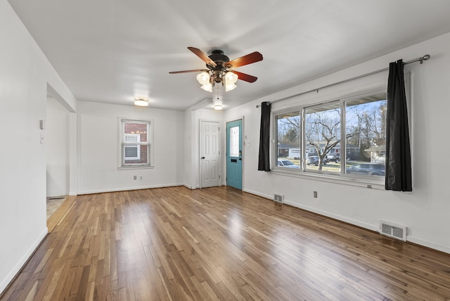 unfurnished room with visible vents, baseboards, and hardwood / wood-style floors