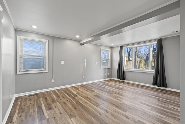 unfurnished room featuring ornamental molding, baseboards, and wood finished floors