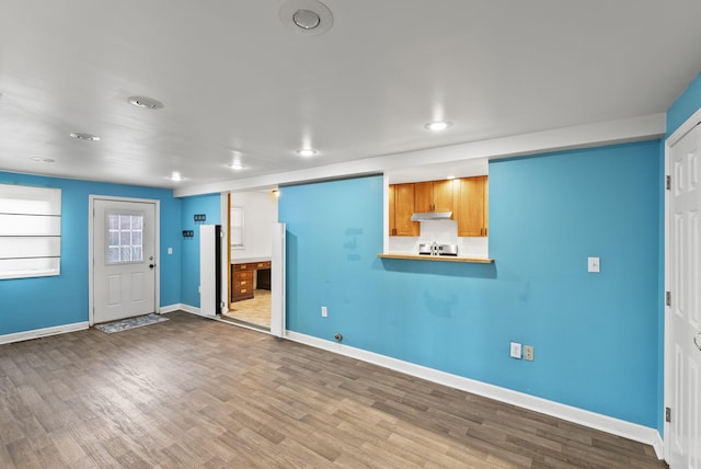 unfurnished living room featuring recessed lighting, baseboards, and wood finished floors