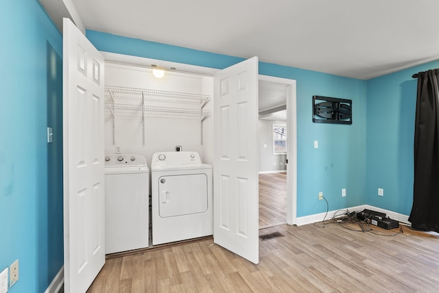 laundry room featuring visible vents, baseboards, laundry area, light wood-style flooring, and separate washer and dryer