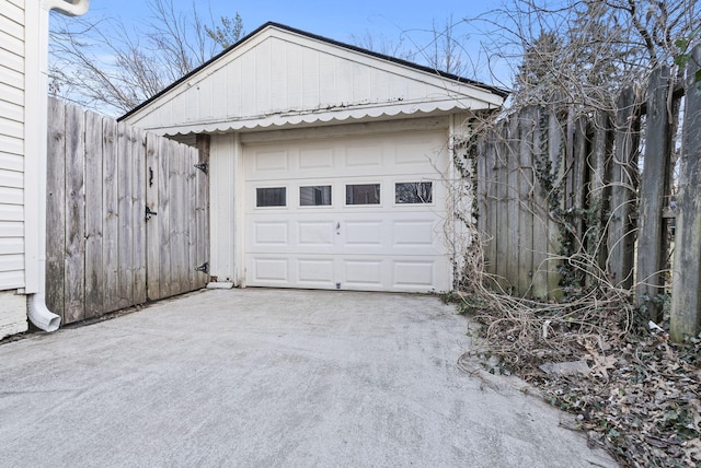 garage featuring driveway and fence