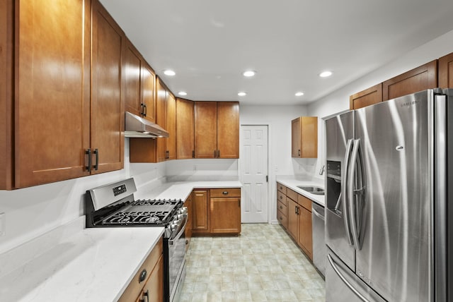 kitchen with recessed lighting, brown cabinets, under cabinet range hood, and stainless steel appliances