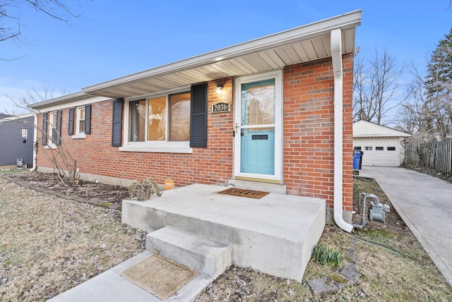 view of front of house featuring an outdoor structure and brick siding