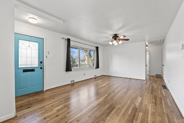 interior space with visible vents, baseboards, hardwood / wood-style floors, and a ceiling fan