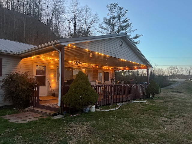 back of property featuring metal roof and a lawn