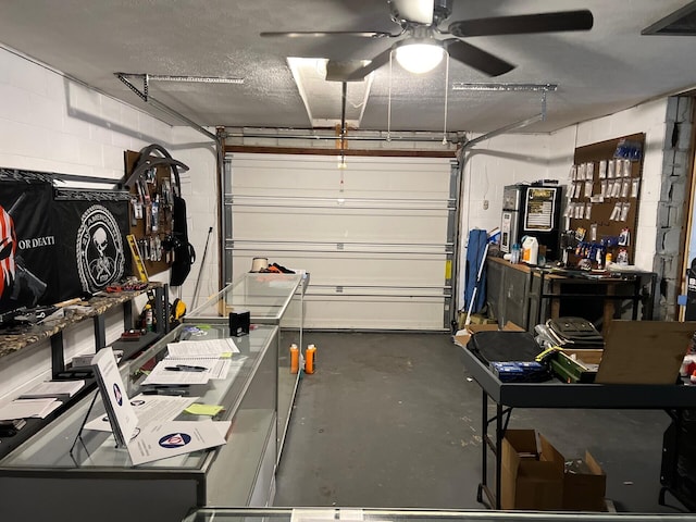 garage featuring concrete block wall and a ceiling fan