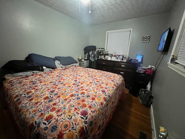 bedroom featuring dark wood finished floors and a textured ceiling