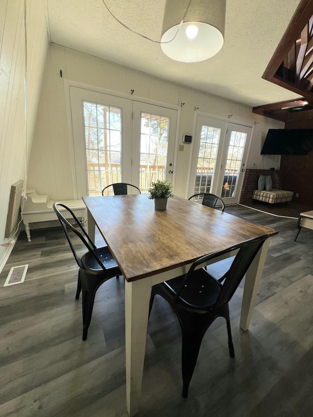 dining space featuring dark wood finished floors, visible vents, and a textured ceiling