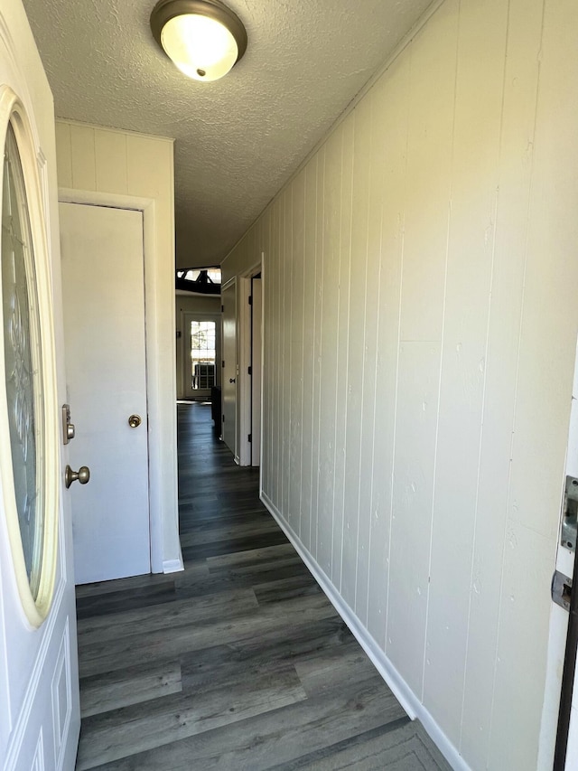 hall featuring a textured ceiling and dark wood-type flooring