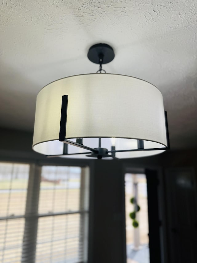 room details featuring a textured ceiling and a chandelier