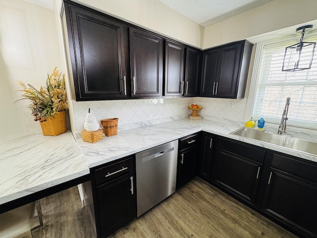 kitchen featuring a sink, decorative light fixtures, tasteful backsplash, wood finished floors, and dishwasher