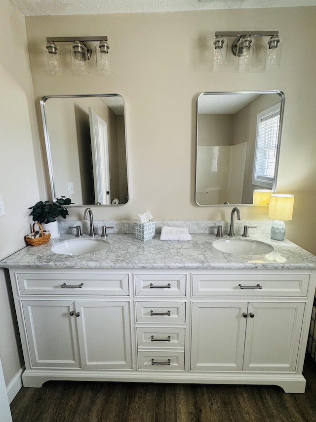 full bath featuring a sink, wood finished floors, and double vanity