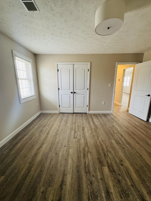 interior space featuring visible vents, plenty of natural light, and wood finished floors