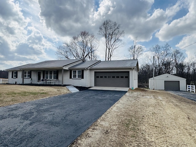 ranch-style house featuring a garage, aphalt driveway, a porch, metal roof, and brick siding