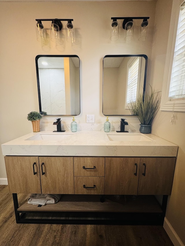 bathroom featuring double vanity, baseboards, and a sink