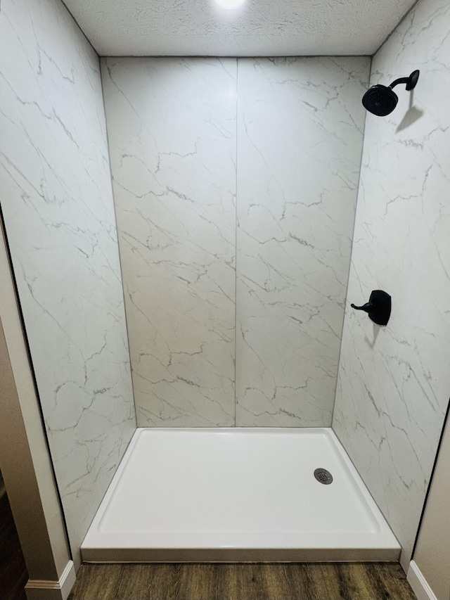 bathroom with a textured ceiling and a shower stall