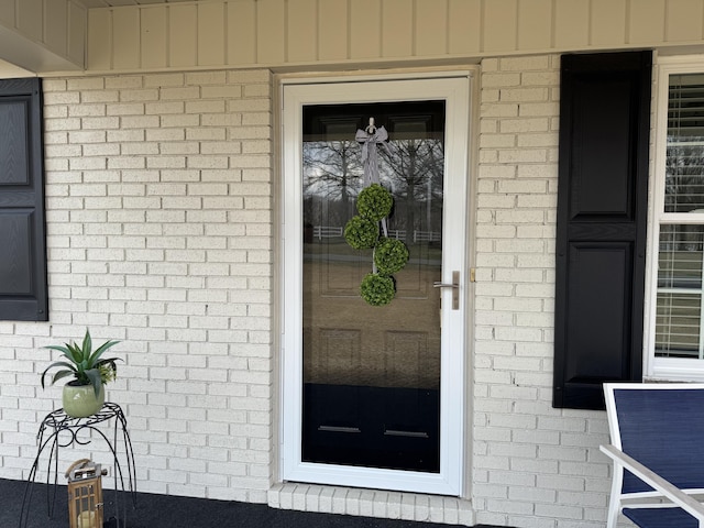 view of exterior entry with brick siding