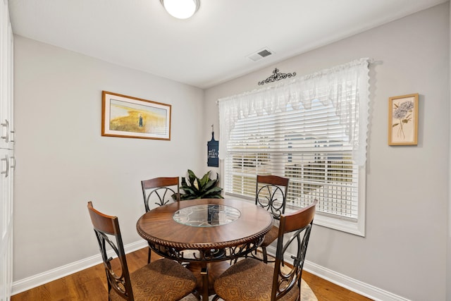 dining space featuring visible vents, baseboards, and wood finished floors