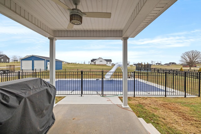 view of patio / terrace featuring a covered pool, a grill, a fenced backyard, and a ceiling fan