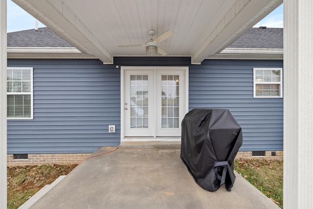 view of exterior entry featuring crawl space, a patio area, a shingled roof, and ceiling fan