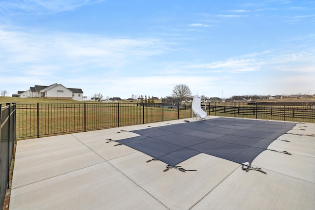 view of swimming pool featuring a patio area, a yard, and fence