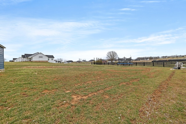 view of yard featuring a rural view, a trampoline, and fence