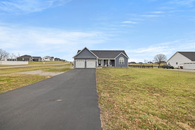 view of front of house with a garage, a front yard, driveway, and fence