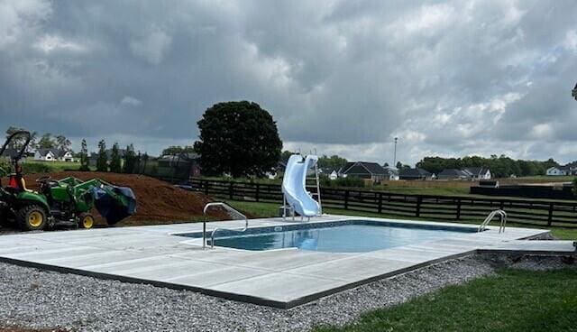 view of pool with a patio area, a fenced in pool, a water slide, and fence