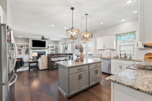 161 Tuscany Way, Richmond, KY 40475 - kitchen featuring stainless steel appliances, a sink, a kitchen island, a fireplace, and a ceiling fan