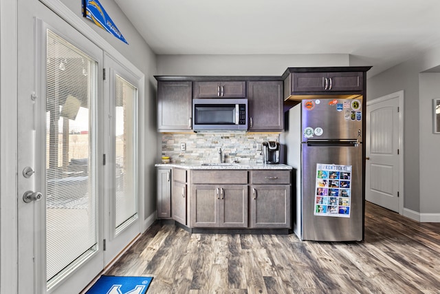 161 Tuscany Way, Richmond, KY 40475 - kitchen featuring appliances with stainless steel finishes, a sink, decorative backsplash, dark brown cabinets, and wood finished floors