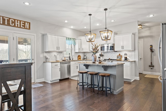 161 Tuscany Way, Richmond, KY 40475 - kitchen featuring appliances with stainless steel finishes, white cabinets, tasteful backsplash, a breakfast bar area, and recessed lighting