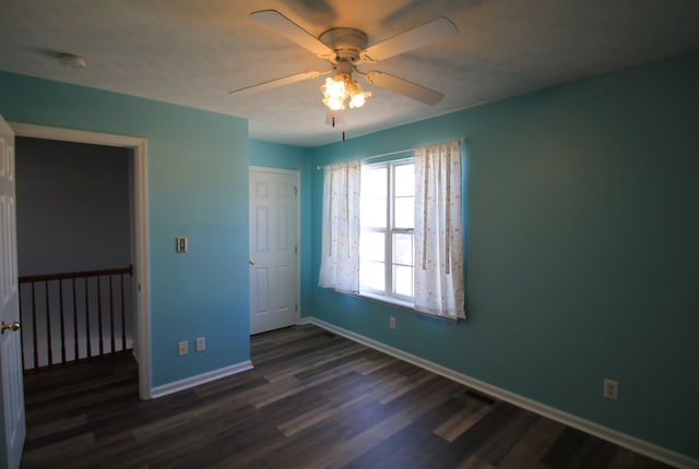 unfurnished bedroom with baseboards, dark wood-style floors, and a ceiling fan