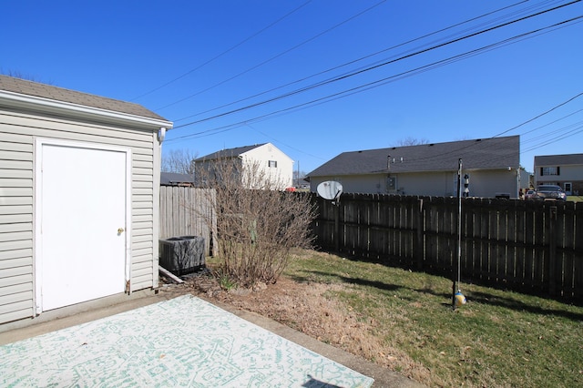 view of yard with a patio area, fence, and an outbuilding