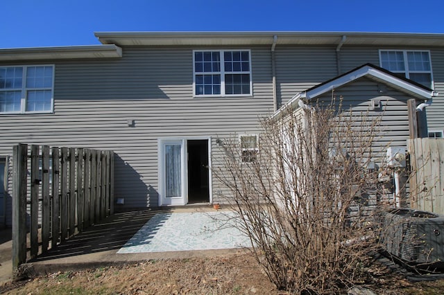 rear view of property featuring a patio, central AC, and fence