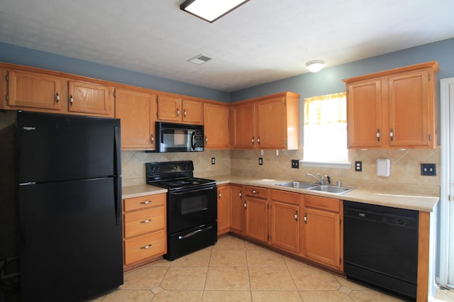 kitchen featuring visible vents, a sink, black appliances, light countertops, and backsplash