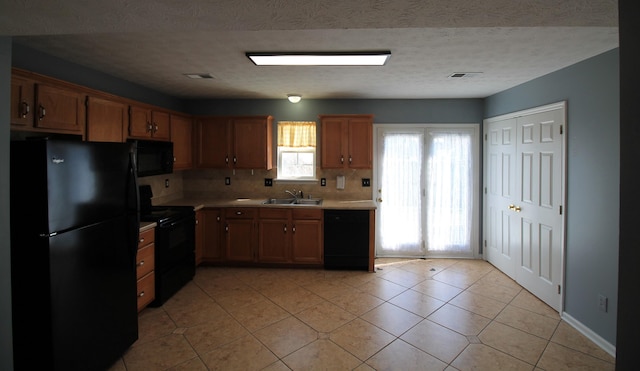 kitchen with visible vents, black appliances, a sink, light tile patterned flooring, and light countertops