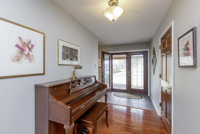 entrance foyer with wood finished floors, baseboards, and a textured ceiling