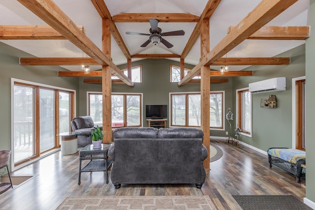 living area featuring beamed ceiling, a wall mounted AC, wood finished floors, baseboards, and ceiling fan