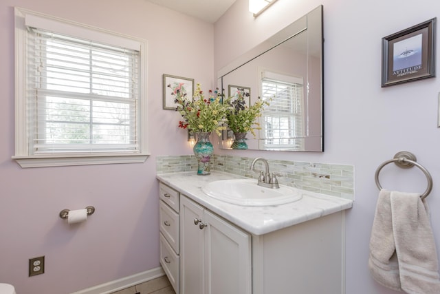 bathroom featuring tasteful backsplash, plenty of natural light, vanity, and baseboards