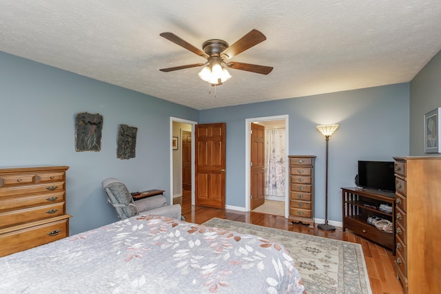 bedroom featuring a textured ceiling, a ceiling fan, baseboards, and wood finished floors