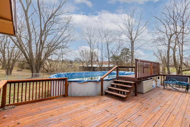 wooden deck featuring a covered pool and fence