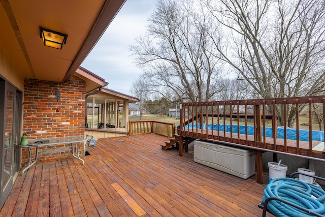 wooden deck featuring a fenced in pool and a sunroom